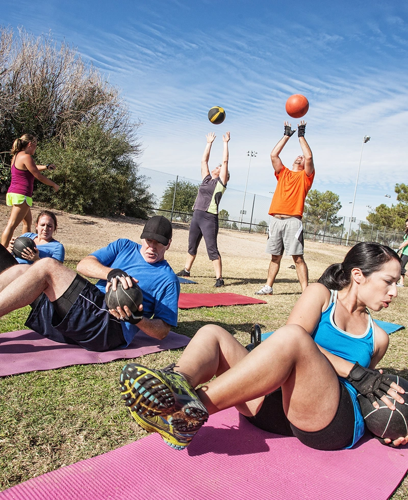 a group of people exercising on mats with balls